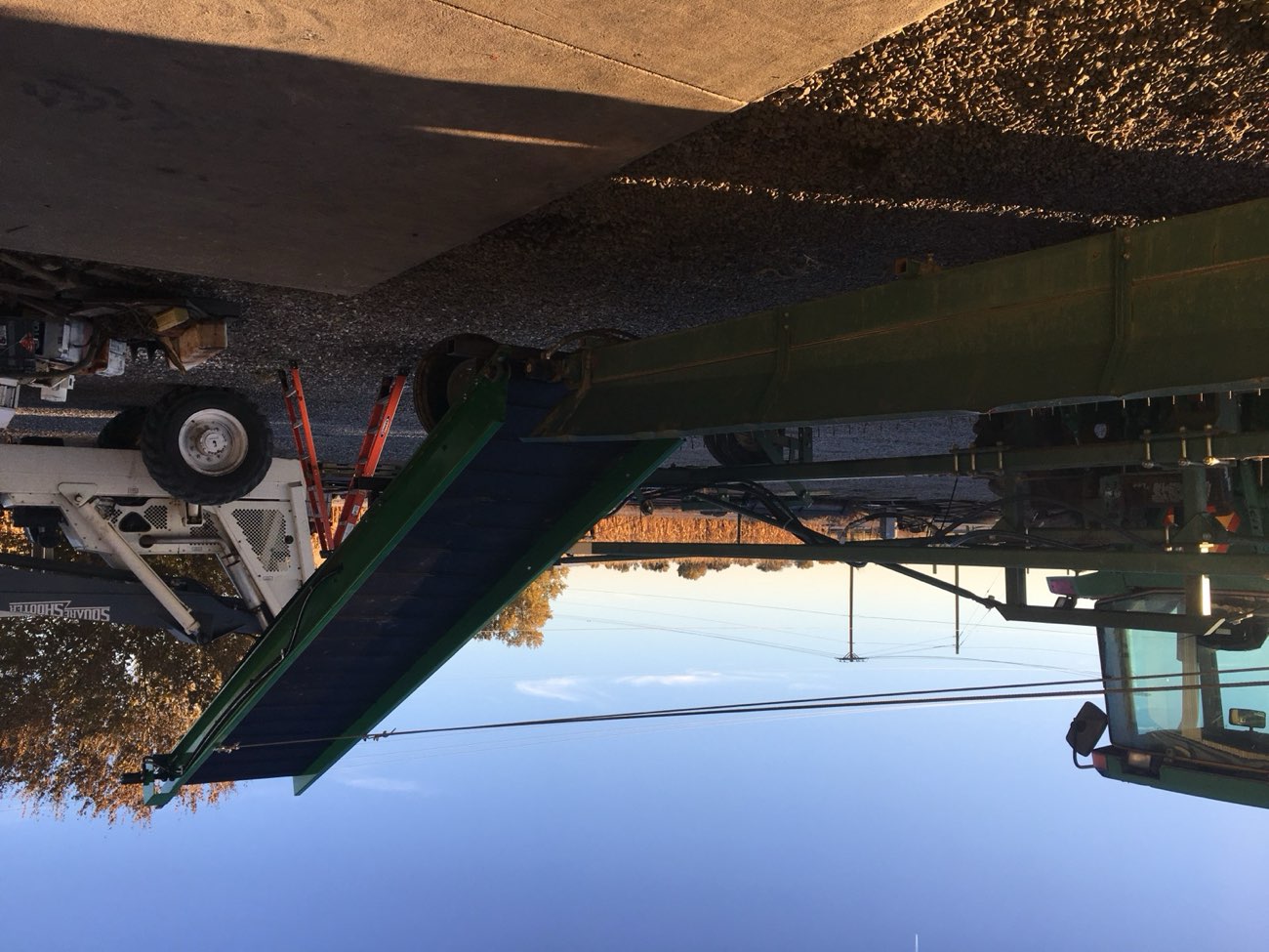 A custom green conveyor fabricated by Ag-Fab, fitted and installed onto a customer's farm harvesting equipment
