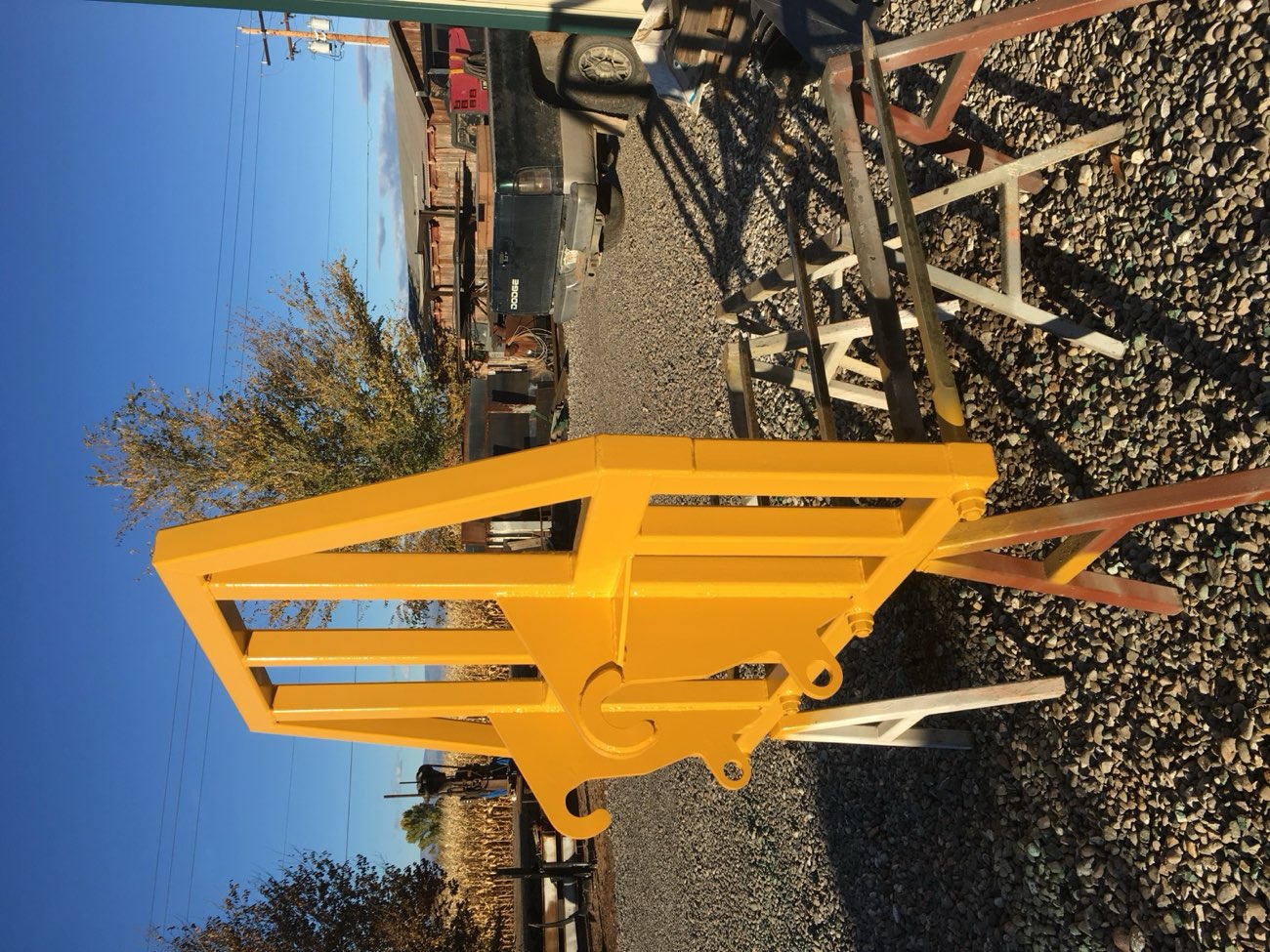 A custom-fabricated steel attachment, primed and painted safety yellow, built by Ag-Fab