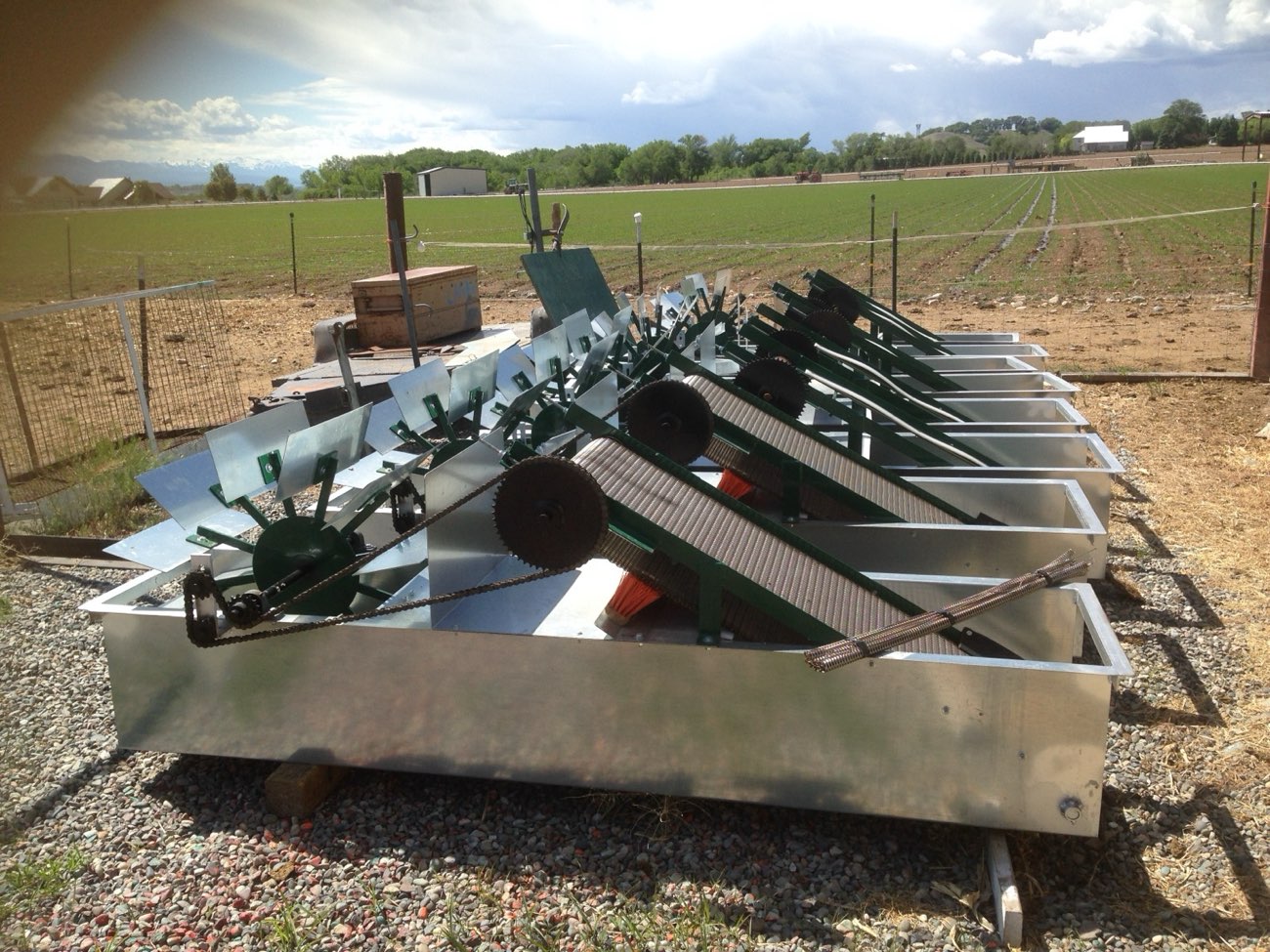 A custom mechanical water cleaner with rotating paddle screen, fabricated and installed at an irrigation headworks in a Colorado field